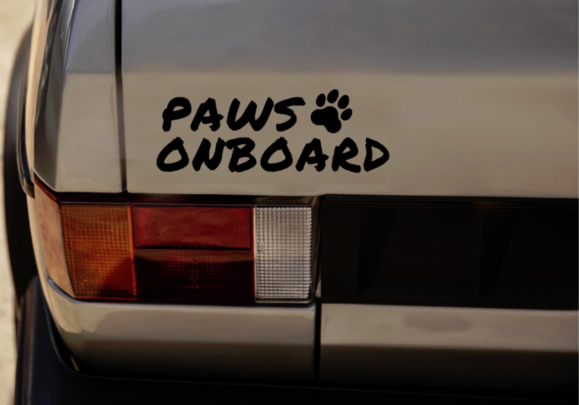 Close-up detail of the Paws Onboard sticker featuring a text logo on a car bumper.