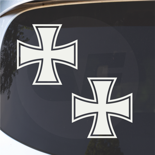 Detail close-up of two white German Iron Cross decals on a smooth surface