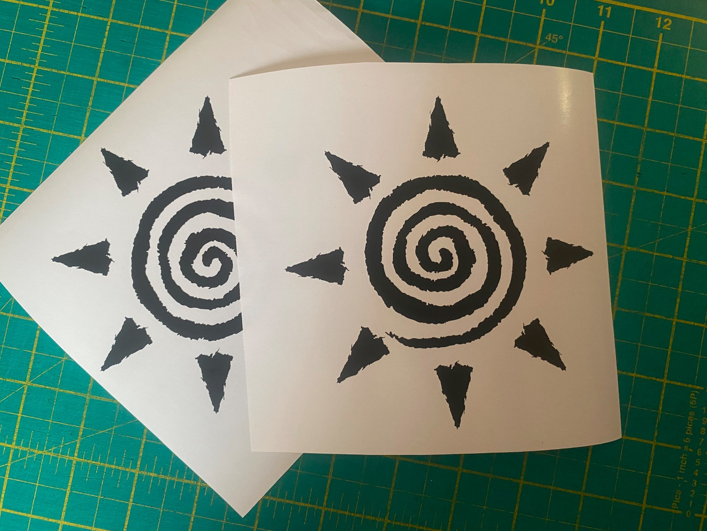 Detail close-up of two sun spiral stickers in black and white.